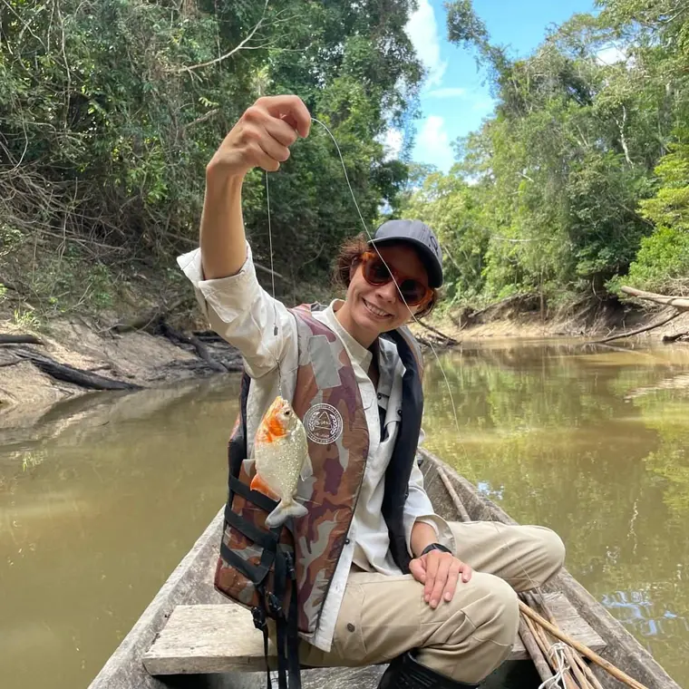 A guest holding a piranha caught from the boat
